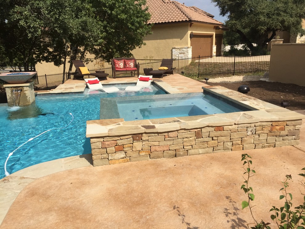 Example of a large mountain style backyard custom-shaped infinity hot tub design in Austin with decking
