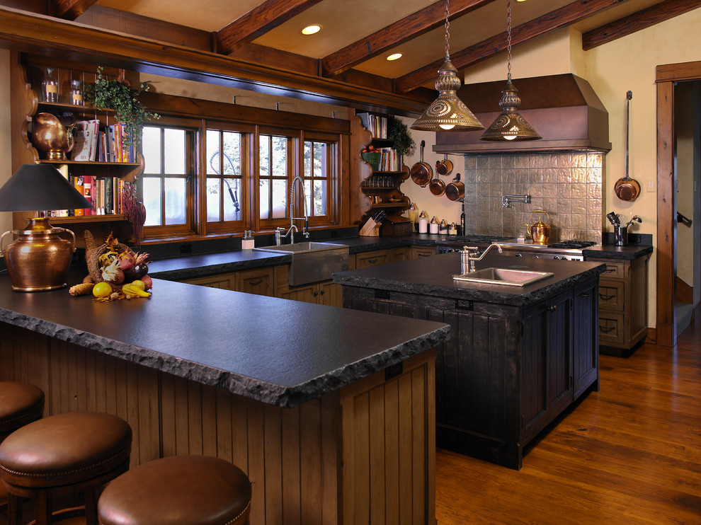 Inspiration for a large country u-shaped separate kitchen in Boise with a farmhouse sink, stainless steel appliances, with island, shaker cabinets, soapstone benchtops, grey splashback, dark wood cabinets and dark hardwood floors.