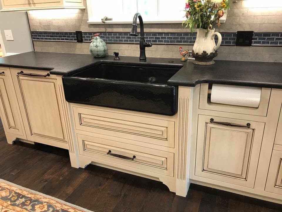 Inspiration for a mid-sized country l-shaped eat-in kitchen in Other with a farmhouse sink, distressed cabinets, stainless steel appliances, raised-panel cabinets, soapstone benchtops, grey splashback, ceramic splashback, dark hardwood floors, with island and brown floor.