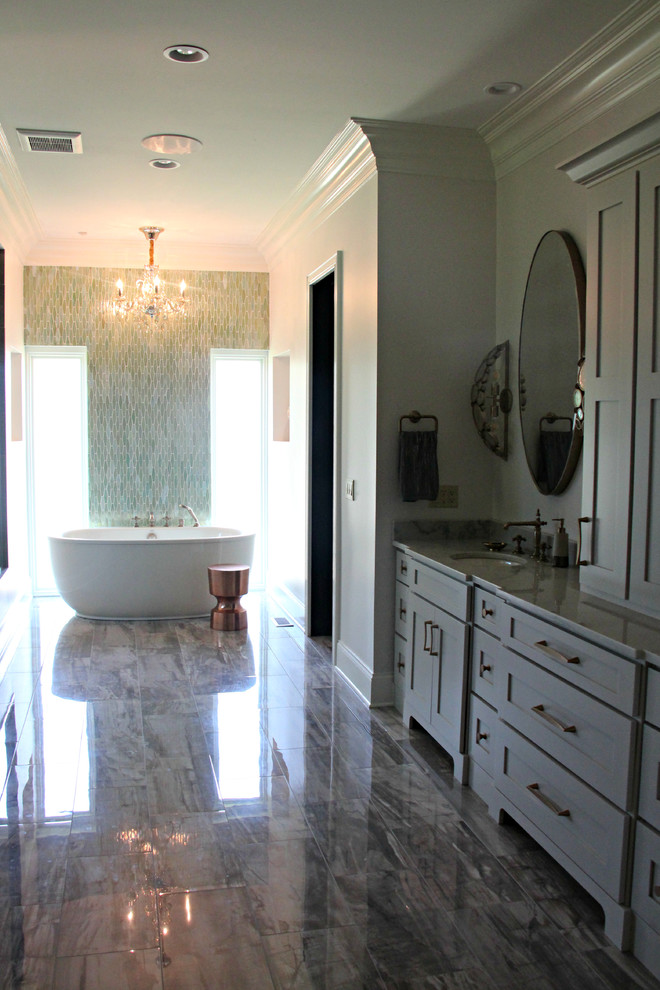 Design ideas for an expansive contemporary master bathroom in St Louis with shaker cabinets, grey cabinets, a freestanding tub, an open shower, gray tile, porcelain tile, grey walls, porcelain floors, an undermount sink, marble benchtops and brown floor.