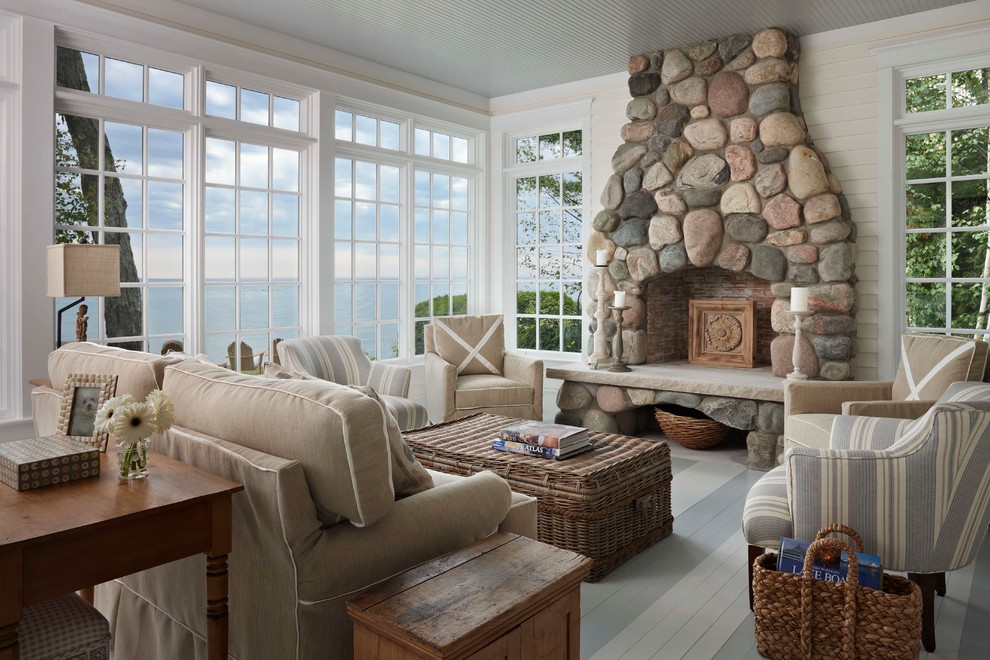 Design ideas for a beach style living room in Other with white walls, a standard fireplace, a stone fireplace surround and painted wood floors.