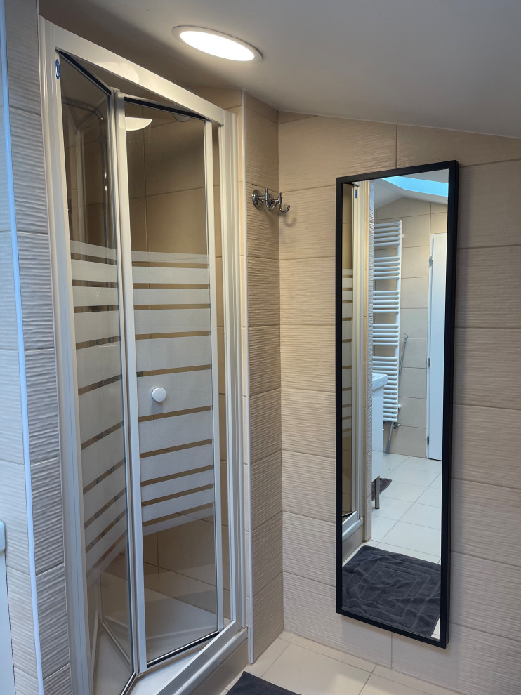 This is an example of a medium sized contemporary ensuite bathroom in Marseille with a submerged bath, a wall mounted toilet, ceramic flooring, beige floors, a sliding door and double sinks.