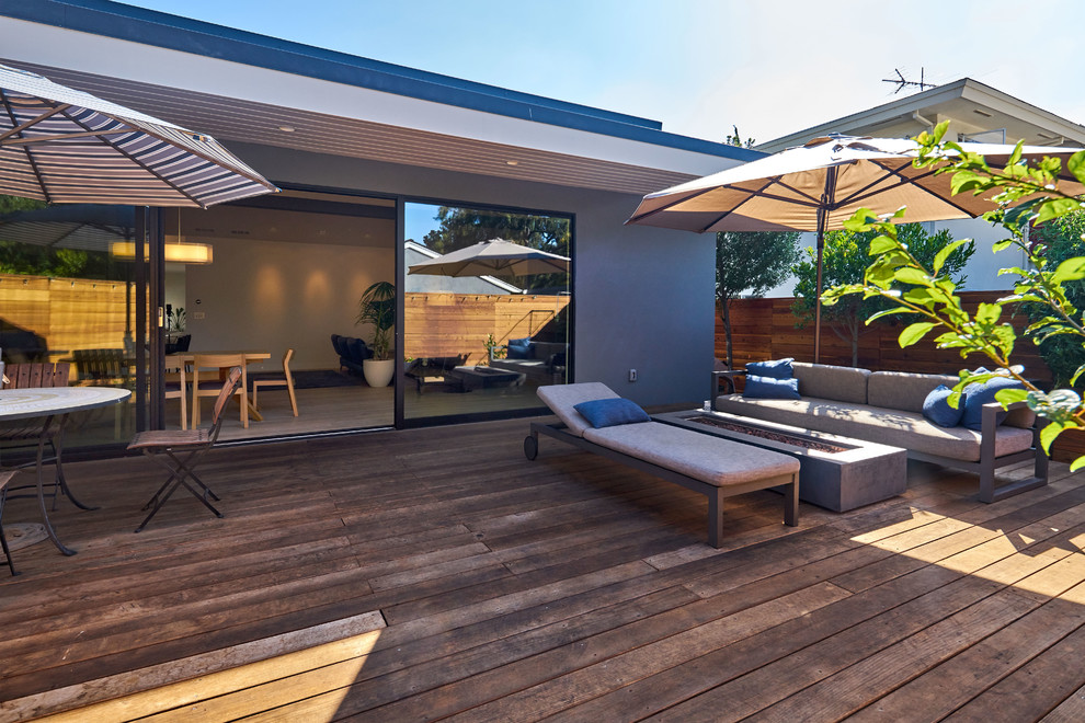 Design ideas for a mid-sized contemporary backyard deck in San Francisco with a fire feature and a roof extension.