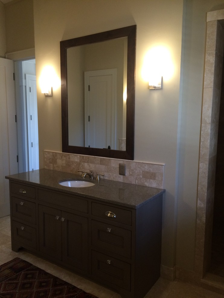 Photo of a large country bathroom in Other with recessed-panel cabinets, dark wood cabinets, a freestanding tub, an alcove shower, a one-piece toilet, beige tile, ceramic tile, beige walls, ceramic floors, an undermount sink and quartzite benchtops.