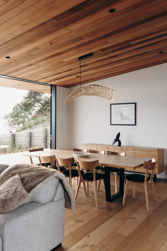 Idee per una sala da pranzo stile marinaro con pareti bianche, pavimento in legno massello medio, pavimento marrone, soffitto a volta e soffitto in legno