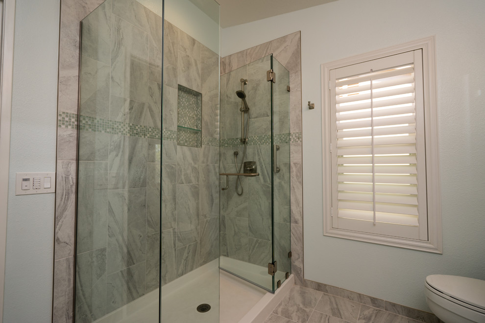 This is an example of a large traditional master bathroom in Los Angeles with recessed-panel cabinets, white cabinets, an alcove shower, a two-piece toilet, yellow tile, ceramic tile, blue walls, travertine floors, a drop-in sink and quartzite benchtops.