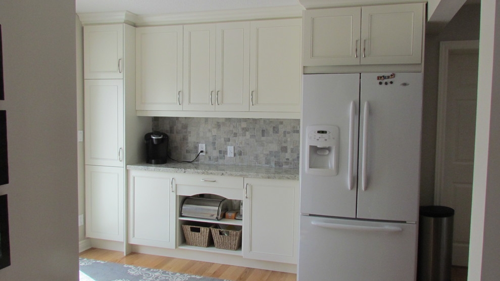 Large transitional eat-in kitchen in Toronto with beaded inset cabinets, white cabinets, granite benchtops, grey splashback, stone tile splashback, white appliances and light hardwood floors.