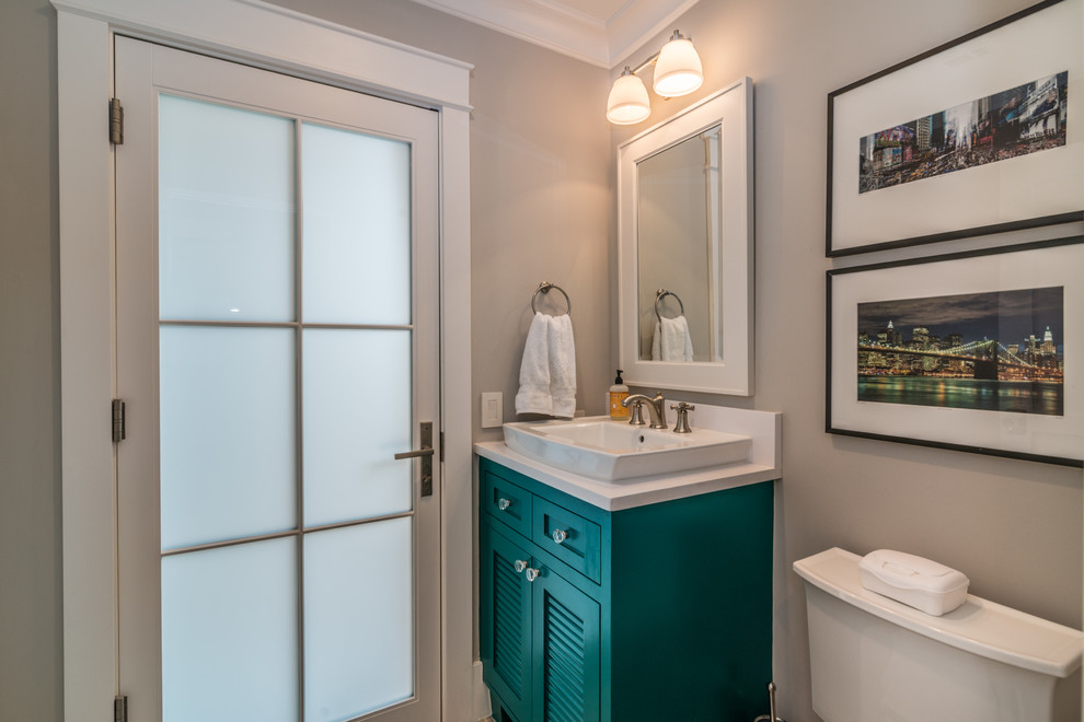 This is an example of a mid-sized modern 3/4 bathroom with turquoise cabinets, a one-piece toilet, beige walls and a trough sink.
