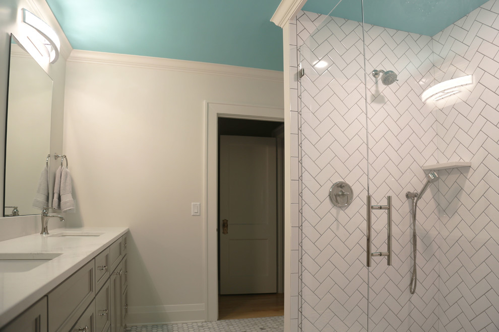 Inspiration for a mid-sized transitional master white tile and porcelain tile porcelain tile bathroom remodel with recessed-panel cabinets, gray cabinets, a two-piece toilet, white walls, an undermount sink and granite countertops