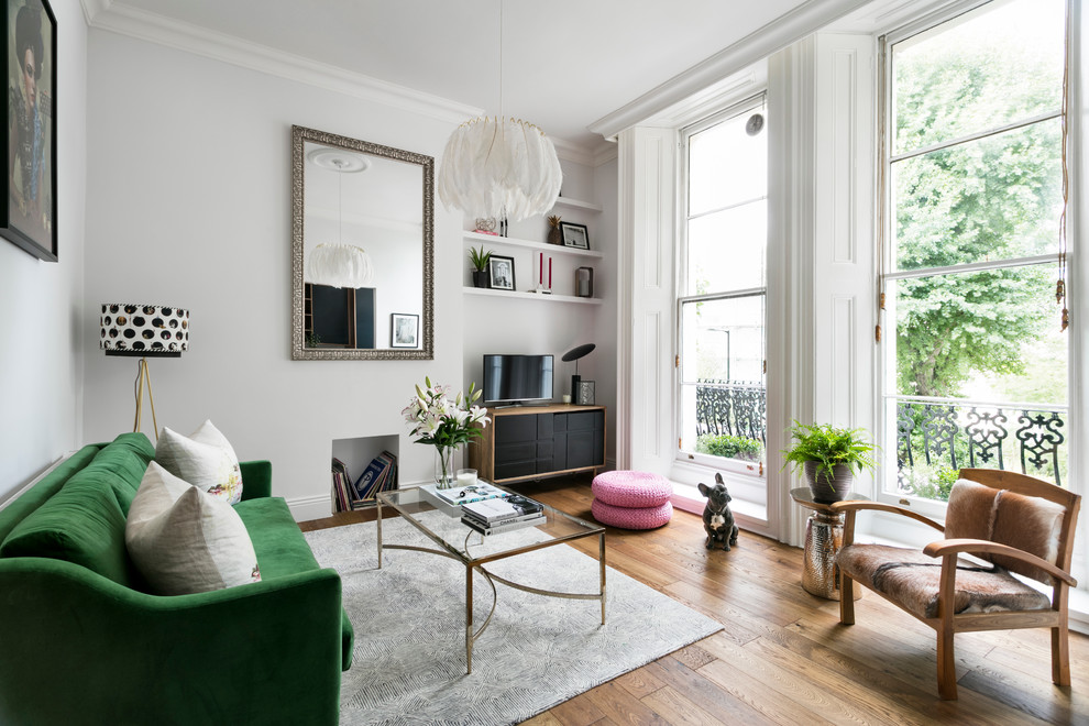 Inspiration for a small eclectic open concept living room in London with white walls, medium hardwood floors, no fireplace and no tv.