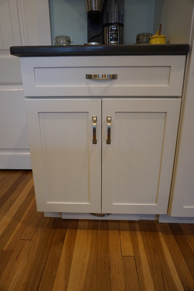 Example of a mid-sized transitional u-shaped medium tone wood floor eat-in kitchen design in Boston with an undermount sink, shaker cabinets, gray cabinets, quartz countertops, black backsplash, stainless steel appliances and an island