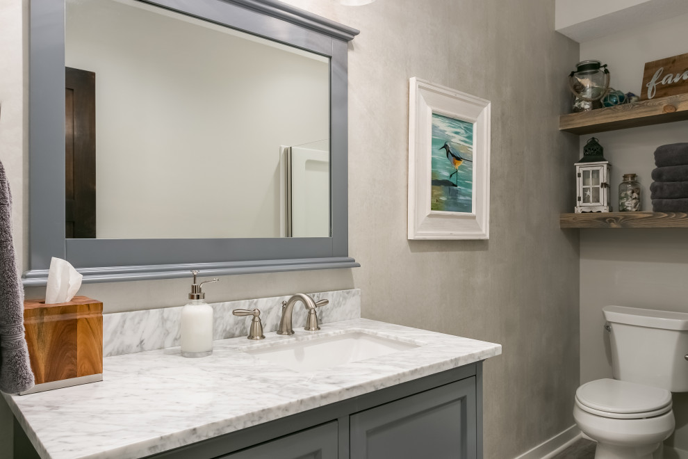 Design ideas for a mid-sized beach style master bathroom in Minneapolis with flat-panel cabinets, grey cabinets, a one-piece toilet, beige tile, beige walls, a drop-in sink, marble benchtops, multi-coloured benchtops, a single vanity and a floating vanity.