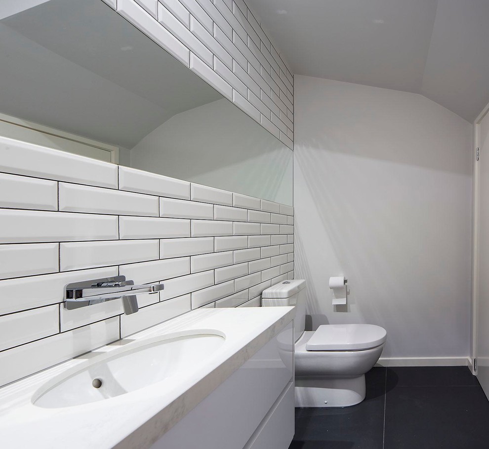 Contemporary bathroom in Melbourne with white cabinets, a one-piece toilet, white tile, subway tile, white walls, ceramic floors, an integrated sink and granite benchtops.