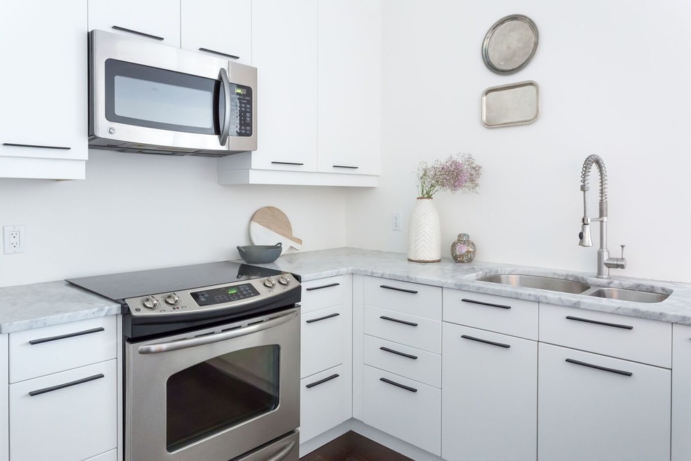 Inspiration for a small transitional u-shaped dark wood floor and brown floor open concept kitchen remodel in Toronto with a double-bowl sink, flat-panel cabinets, white cabinets, quartzite countertops, white backsplash, stainless steel appliances and a peninsula