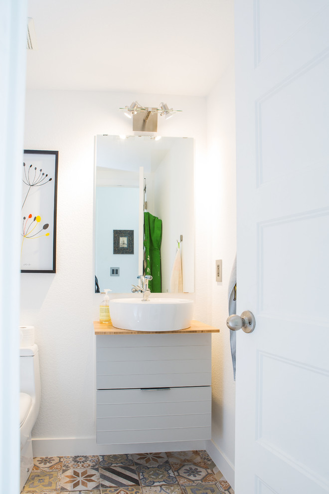 Photo of a mid-sized contemporary 3/4 bathroom in Denver with flat-panel cabinets, grey cabinets, a one-piece toilet, white tile, ceramic tile, white walls, porcelain floors, a vessel sink, wood benchtops, multi-coloured floor and beige benchtops.