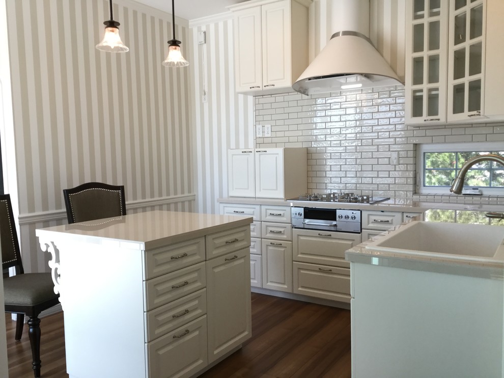 Inspiration for a traditional l-shaped kitchen in Sapporo with an integrated sink, raised-panel cabinets, white cabinets, white splashback, medium hardwood floors and brown floor.