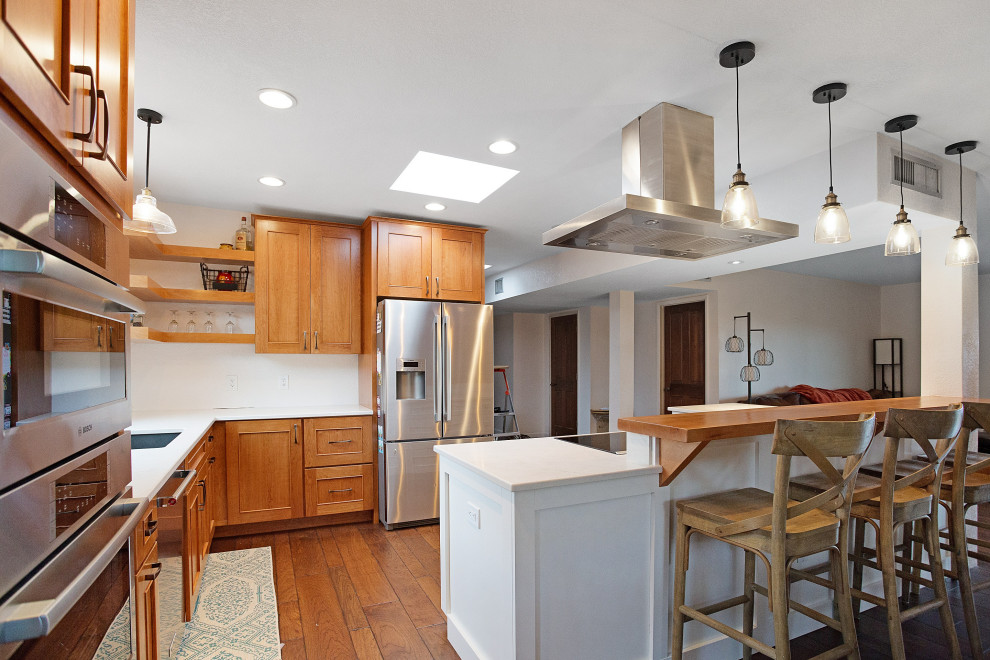 Example of a mid-sized l-shaped dark wood floor and brown floor eat-in kitchen design with an undermount sink, shaker cabinets, white cabinets, quartz countertops, stainless steel appliances, an island and white countertops