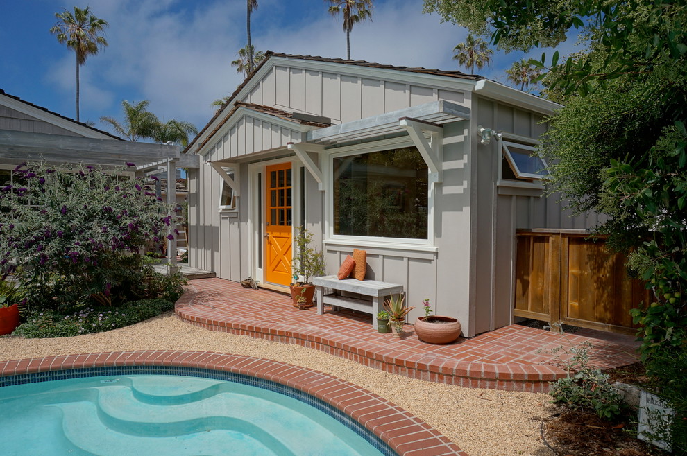 Beach style backyard verandah in San Diego with brick pavers and a roof extension.
