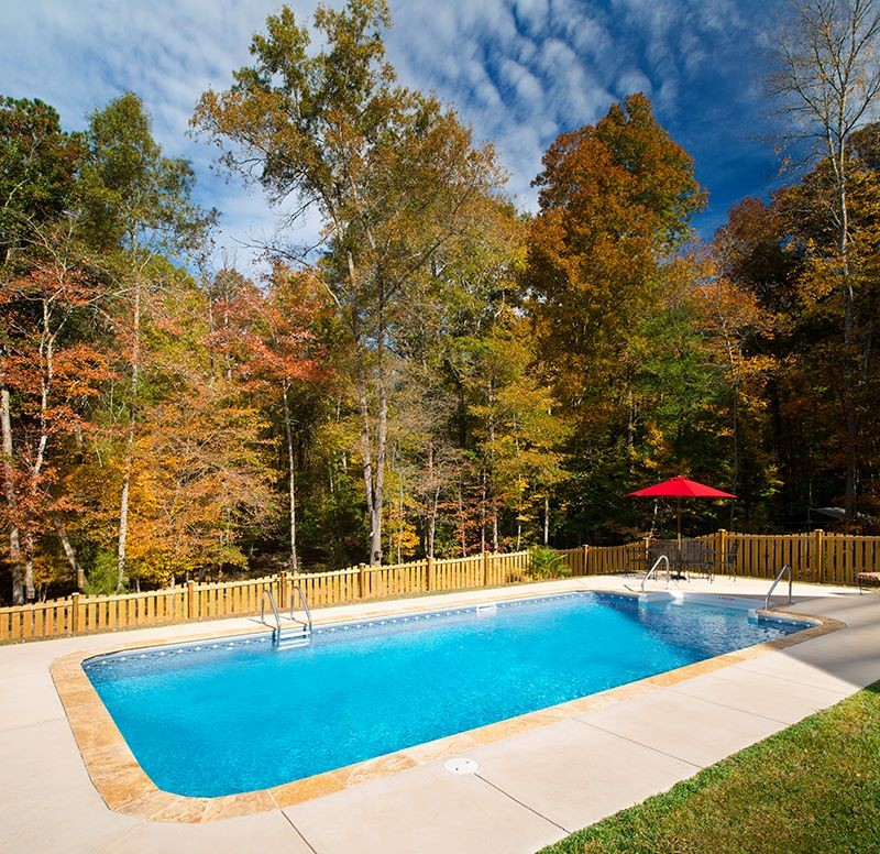 Example of a backyard stamped concrete and rectangular pool design