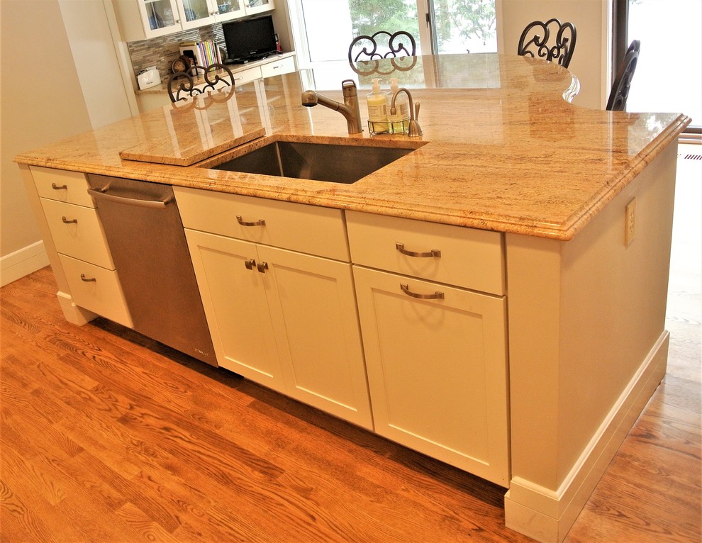 Example of a transitional light wood floor kitchen design in Boston with an undermount sink, shaker cabinets, white cabinets, granite countertops, stainless steel appliances and an island