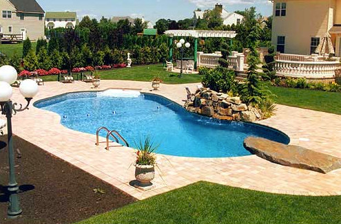 Inspiration for a backyard stone and custom-shaped pool remodel