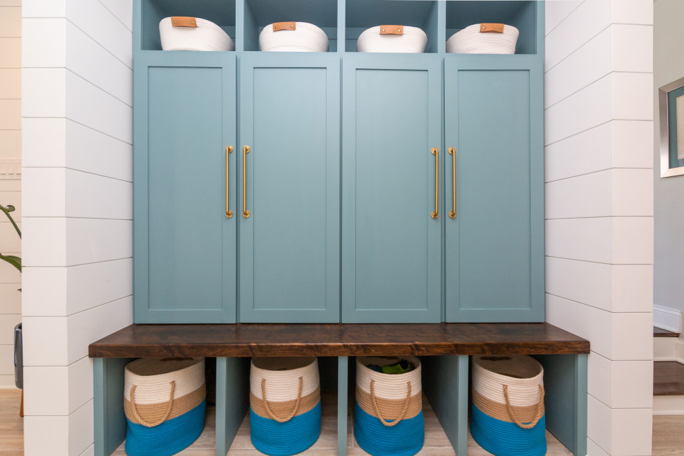Photo of a medium sized beach style boot room in Baltimore with white walls, ceramic flooring, a single front door, a blue front door, multi-coloured floors and tongue and groove walls.