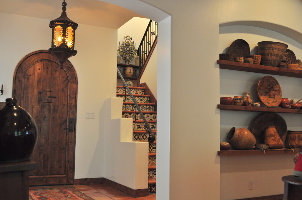 Mid-sized foyer in Austin with white walls, terra-cotta floors, a single front door and a dark wood front door.