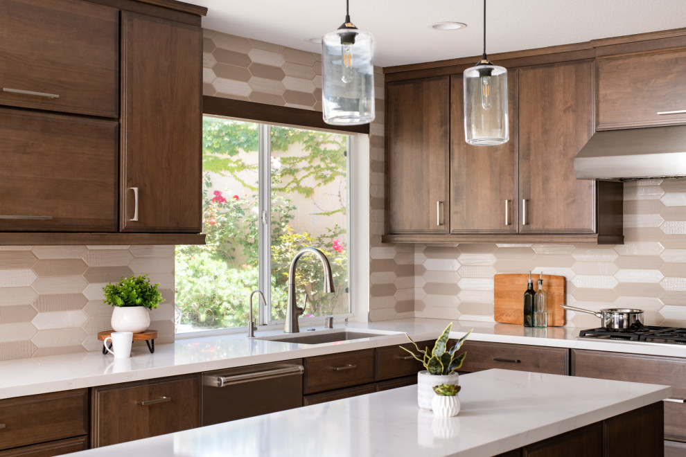 Design ideas for a medium sized classic u-shaped kitchen/diner in Orange County with shaker cabinets, brown cabinets, engineered stone countertops, beige splashback, porcelain splashback, stainless steel appliances, an island and white worktops.