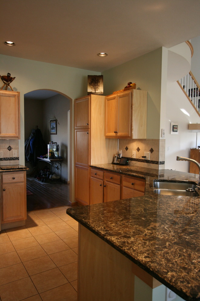 Mid-sized transitional l-shaped ceramic tile open concept kitchen photo with an undermount sink, recessed-panel cabinets, light wood cabinets, quartz countertops, beige backsplash, ceramic backsplash, stainless steel appliances, green walls and a peninsula