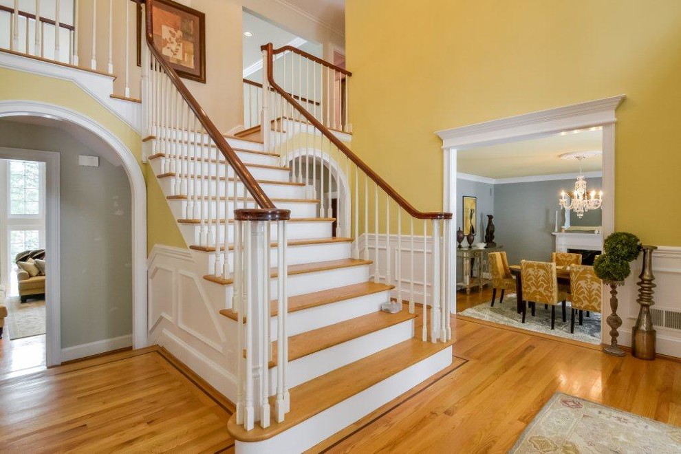 Design ideas for a large traditional wood straight staircase in New York with painted wood risers and wood railing.