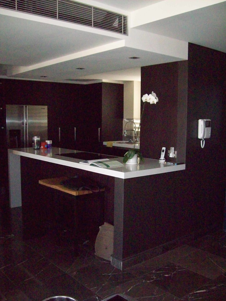 Photo of a mid-sized modern u-shaped eat-in kitchen in Sydney with an undermount sink, quartz benchtops, metallic splashback, porcelain floors and a peninsula.