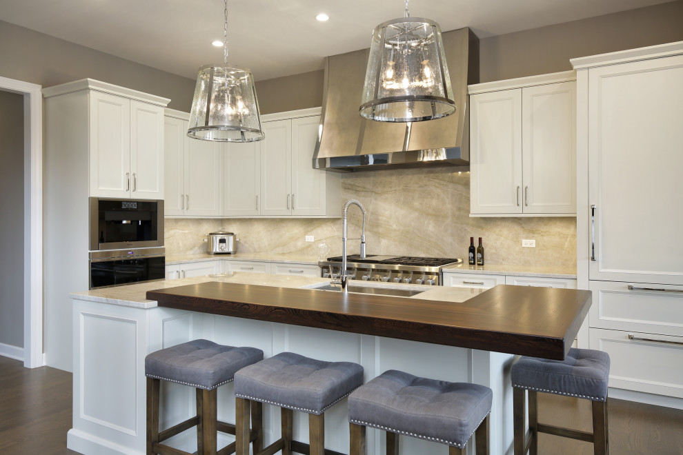 Example of a transitional l-shaped dark wood floor and brown floor kitchen design in Chicago with an undermount sink, shaker cabinets, white cabinets, gray backsplash, stone slab backsplash, stainless steel appliances, an island, gray countertops and quartzite countertops