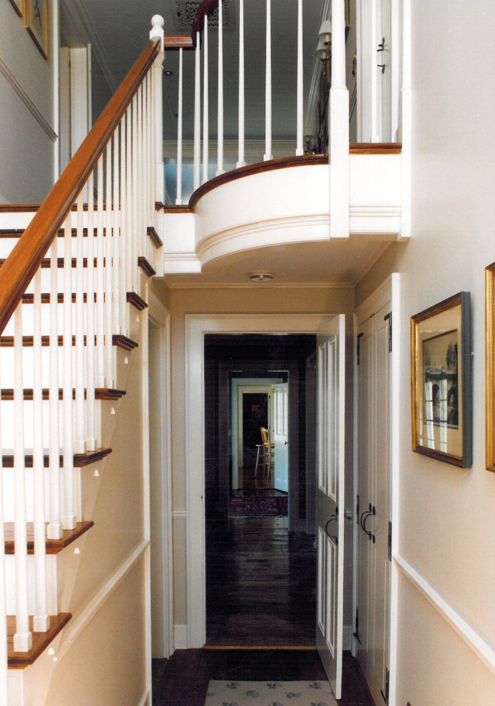 Large traditional wood straight staircase in Boston with wood risers and wood railing.