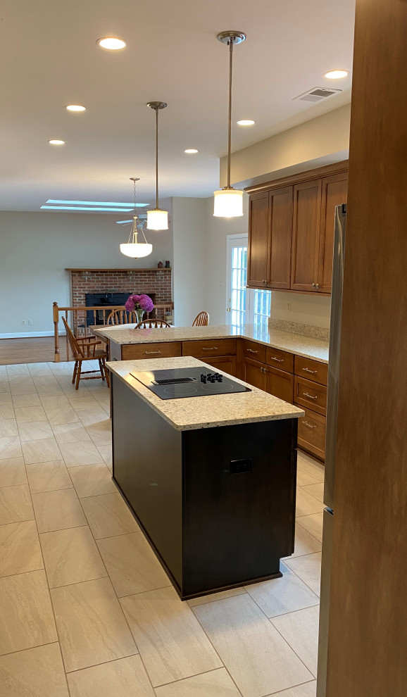 This is an example of a large traditional u-shaped eat-in kitchen in DC Metro with a double-bowl sink, flat-panel cabinets, brown cabinets, quartz benchtops, stainless steel appliances, porcelain floors, with island, beige floor and beige benchtop.
