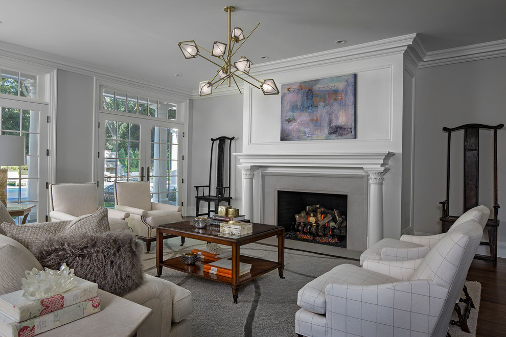 Large traditional formal open concept living room in Detroit with grey walls, dark hardwood floors, a standard fireplace, a stone fireplace surround, no tv and brown floor.