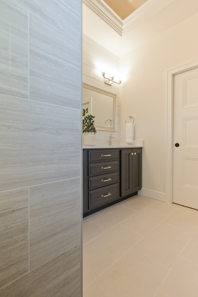 Photo of a transitional bathroom in Other with raised-panel cabinets, dark wood cabinets, beige tile, porcelain tile, ceramic floors, beige floor, a built-in vanity and planked wall panelling.