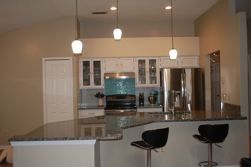 Example of a transitional u-shaped kitchen design in Jacksonville with shaker cabinets, white cabinets and granite countertops