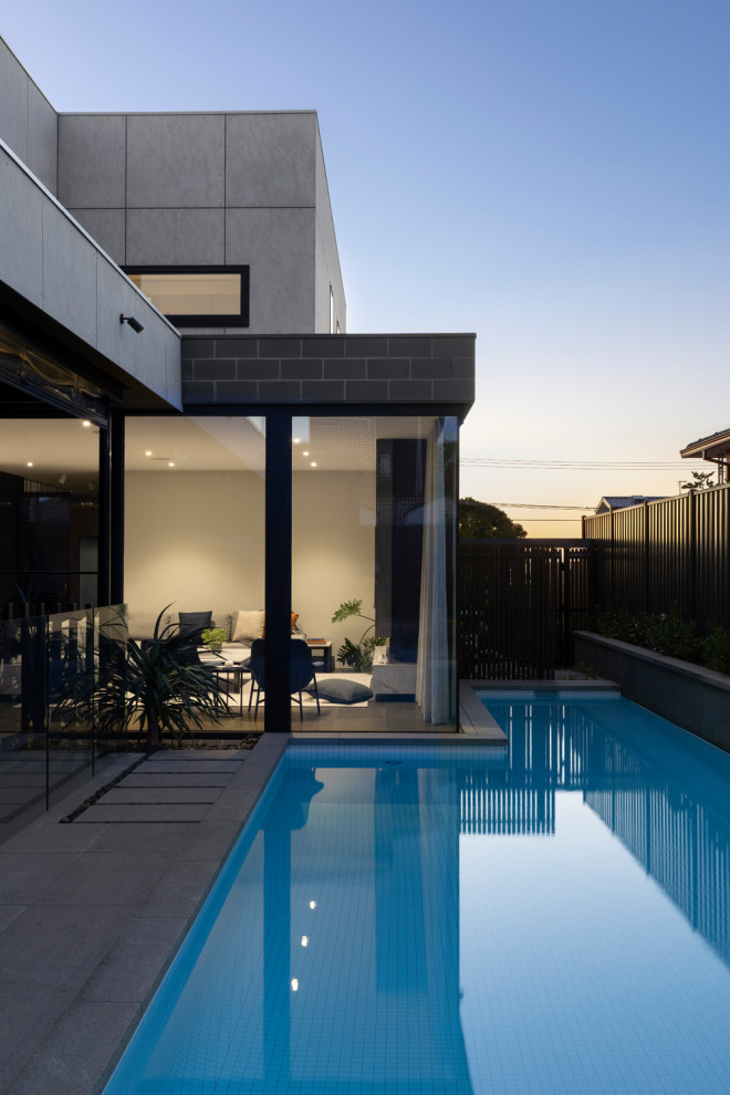 Design ideas for a large modern l-shaped pool in Melbourne with natural stone pavers.