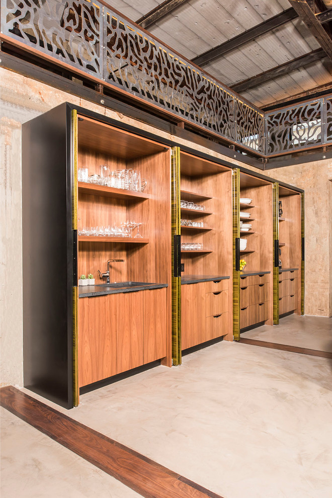 Large industrial galley kitchen pantry in Raleigh with an undermount sink, flat-panel cabinets, dark wood cabinets, granite benchtops, panelled appliances, concrete floors, multiple islands and beige floor.