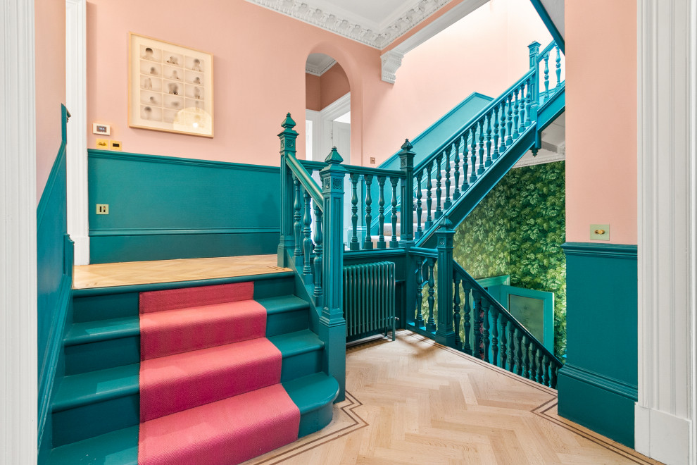 Пример оригинального дизайна: п-образная лестница в стиле фьюжн с крашенными деревянными ступенями, крашенными деревянными подступенками, деревянными перилами и панелями на стенах