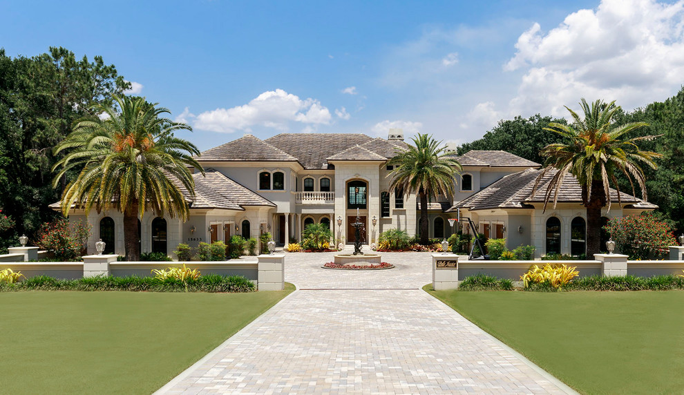 Expansive mediterranean two-storey beige house exterior in Orlando with a hip roof.