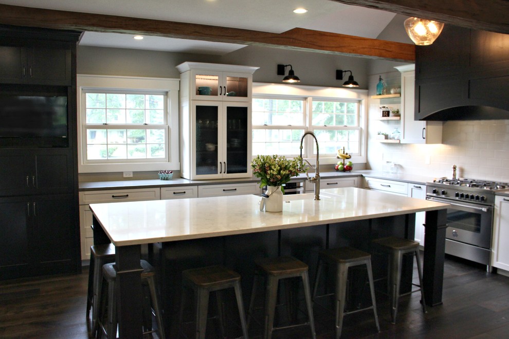 Mid-sized mountain style l-shaped medium tone wood floor and brown floor eat-in kitchen photo with a farmhouse sink, shaker cabinets, white cabinets, quartz countertops, white backsplash, subway tile backsplash and stainless steel appliances