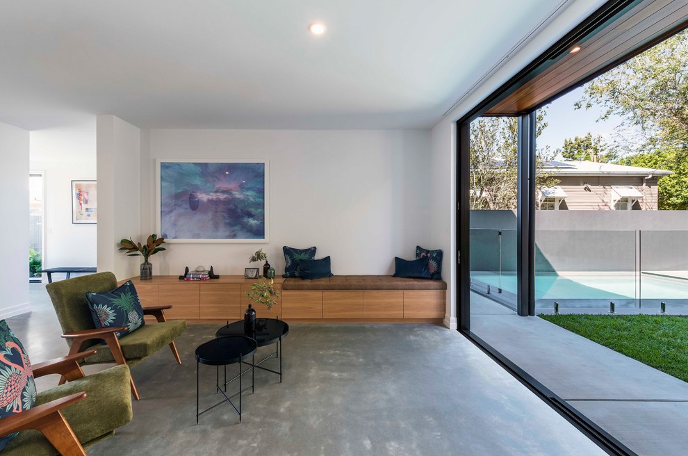 This is an example of a contemporary formal open concept living room in Brisbane with white walls, concrete floors and grey floor.
