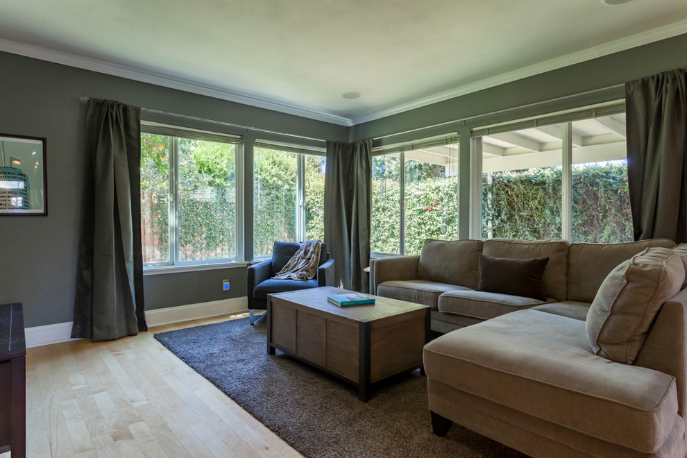 Mid-sized trendy open concept light wood floor and brown floor family room photo in Los Angeles with gray walls and a tv stand