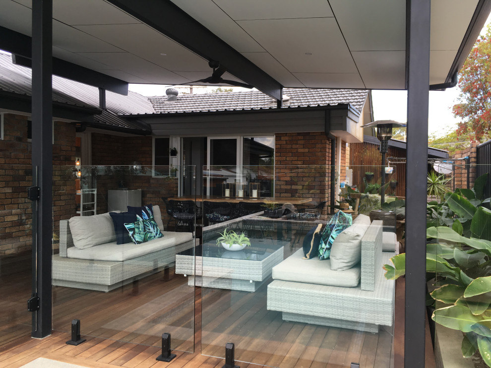 Photo of a large modern side yard deck in Brisbane with a pergola.