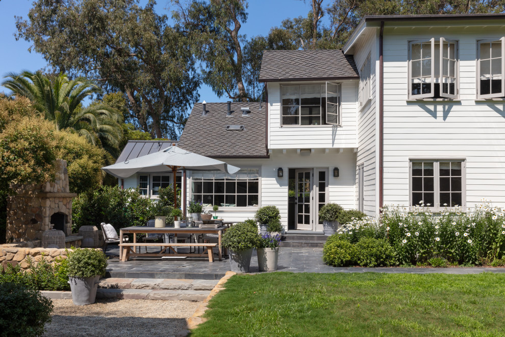 Rustikaler Patio hinter dem Haus mit Kamin und Natursteinplatten in Santa Barbara