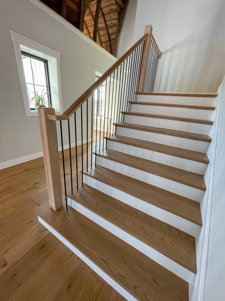 Photo of an expansive transitional wood straight staircase in DC Metro with wood risers and mixed railing.
