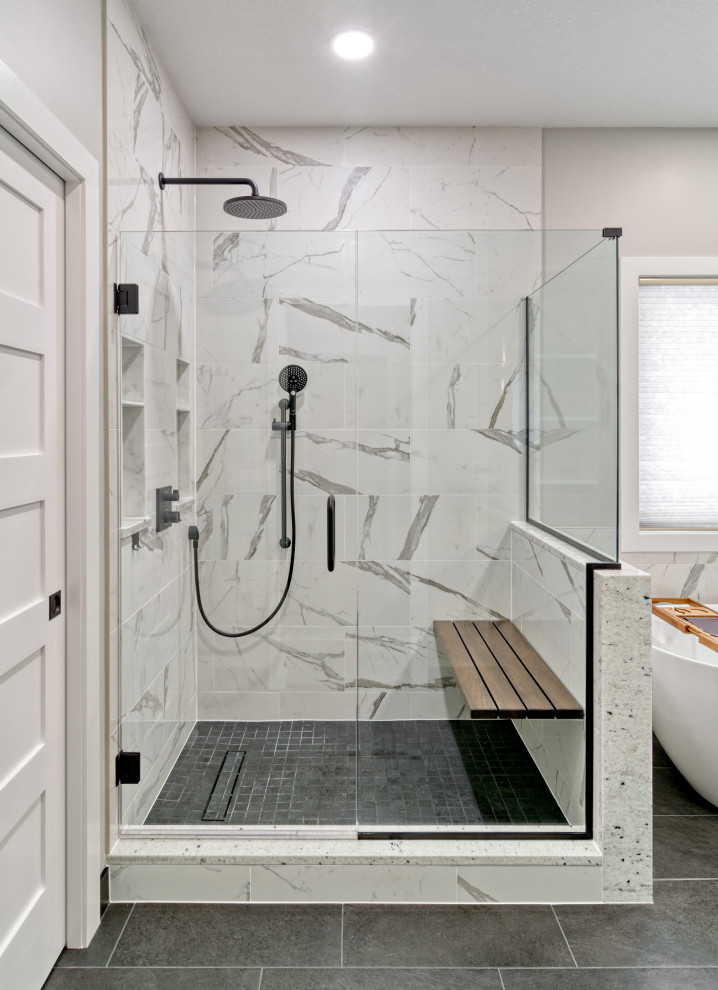 This is an example of a large transitional master bathroom in Minneapolis with flat-panel cabinets, medium wood cabinets, a freestanding tub, a corner shower, a two-piece toilet, green tile, porcelain tile, white walls, porcelain floors, an undermount sink, granite benchtops, black floor, a hinged shower door, white benchtops, a shower seat, a double vanity, a floating vanity and decorative wall panelling.