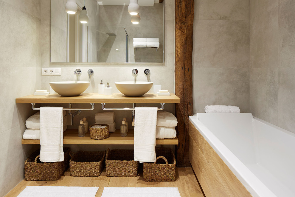 This is an example of a mid-sized contemporary master bathroom in Other with open cabinets, medium wood cabinets, an alcove tub, a shower/bathtub combo, a vessel sink, wood benchtops and beige benchtops.