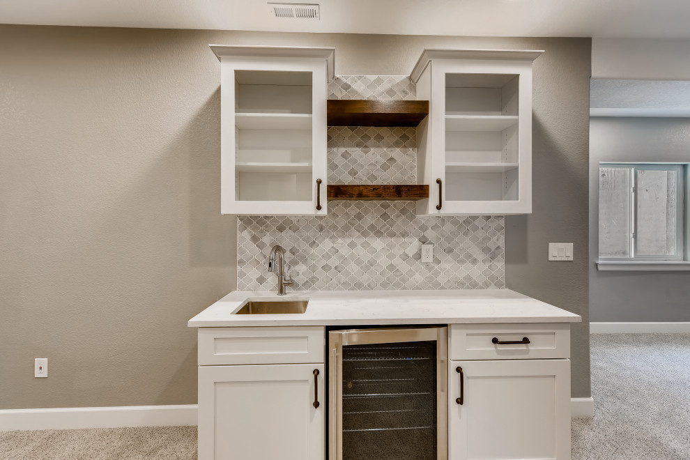 Inspiration for a mid-sized country single-wall wet bar in Denver with an undermount sink, recessed-panel cabinets, white cabinets, quartzite benchtops, white splashback, ceramic splashback, carpet, white floor and white benchtop.